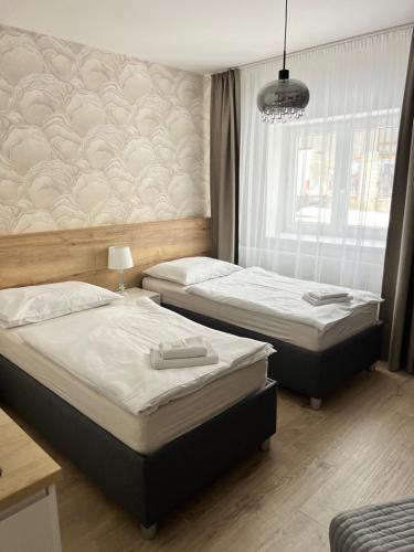 2 camas individuales en un dormitorio con ventana en Ubytování Cukrovar, en Lovosice
