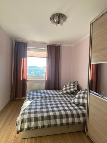 sypialnia z łóżkiem z 2 poduszkami i oknem w obiekcie Apartament Rakownica w Jeleniej Górze