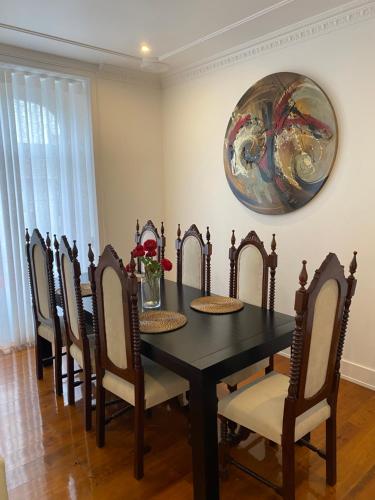 a dining room table with chairs and a painting on the wall at Arroios - Fourth Floor in Lisbon
