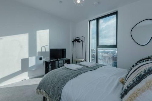 um quarto branco com uma cama e uma grande janela em Stunning 2-Bed Premium Apartment - Free WI-FI em Preston