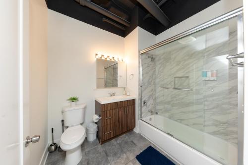 a bathroom with a toilet and a glass shower at McCormick Place 2b-2b family unit with optional parking sleeps up to 6 in Chicago