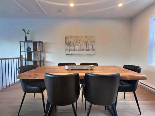 a dining room with a wooden table and chairs at Le domaine du Sous-Bois in Mont-Blanc