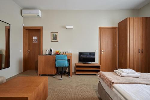 a bedroom with a bed and a desk and a television at Palanga Visit Apartments and SPA in Palanga