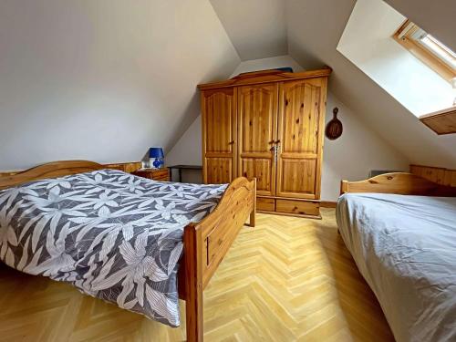 um quarto com uma cama e um armário de madeira em Chalet Berck-Plage, 4 pièces, 5 personnes - FR-1-646-46 em Berck-sur-Mer