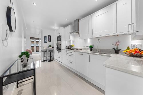 a white kitchen with white counters and white cabinets at Elegant Serviced Apartment Studio - Central London in London