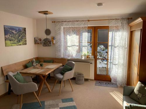 - un salon avec une table et des chaises en bois dans l'établissement Ferienwohnung Bergleuchten, à Obermaiselstein