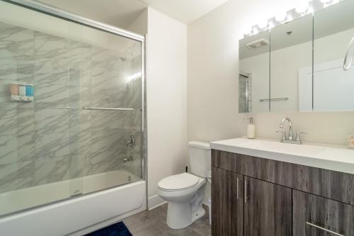 a bathroom with a shower and a toilet and a sink at McCormick Place modern 2br-2ba Loft with optional parking for 6 guests in Chicago