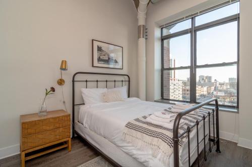 1 dormitorio con cama y ventana grande en McCormick Place modern 2br-2ba Loft with optional parking for 6 guests, en Chicago