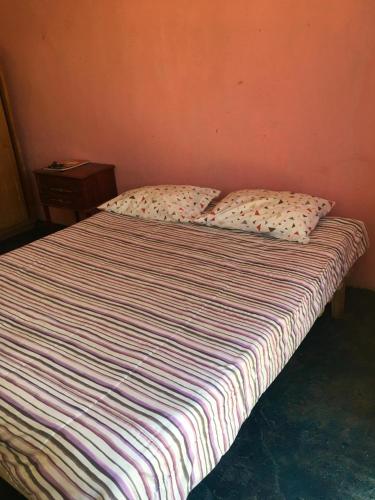 a bed in a room with two pillows on it at Habitación en Casa Familiar 