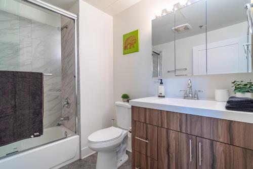 y baño con aseo, lavabo y ducha. en McCormick Place modern loft with an amazing city skyline view and optional parking for 6 guests, en Chicago