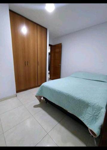 - une chambre avec un grand lit et des placards en bois dans l'établissement Apto en Milan. Zona rosa, à Manizales