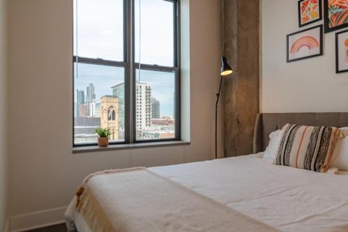 a bedroom with a bed with a view of a city at McCormick Place modern loft with an amazing city skyline view and optional parking for 6 guests in Chicago