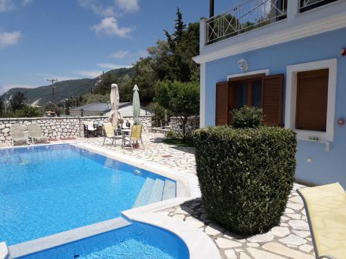 a villa with a swimming pool and a house at AGIOS NIKITAS DOLPHINS in Agios Nikitas