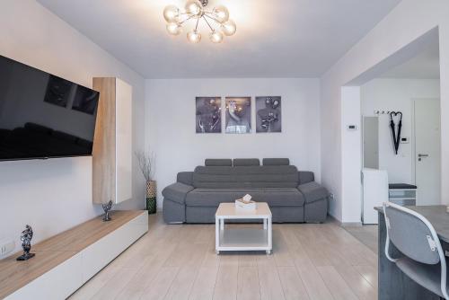 un soggiorno con divano e tavolo di Apartment with free parking near Coresi Mall by MM Apartments a Braşov