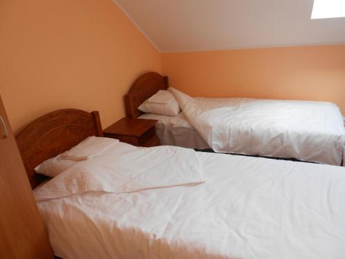 two beds in a room with white sheets at Tee Motell in Viitna