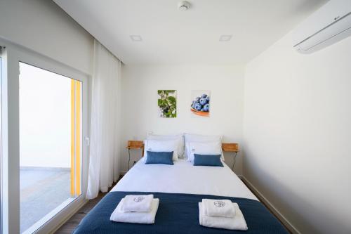 um quarto com uma cama e uma grande janela em Ericeira TreeGarden em Ericeira