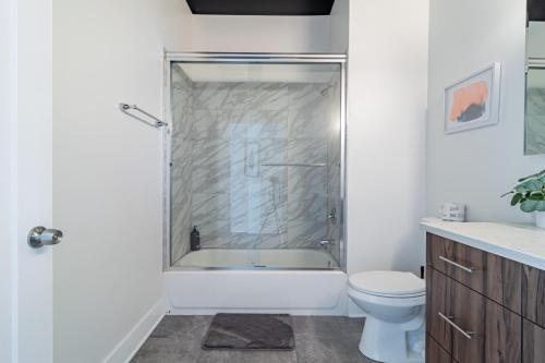 a bathroom with a shower with a toilet and a sink at McCormick Place luxury corner apartment with optional parking for 6 guests in Chicago