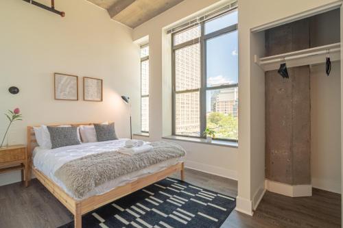 a bedroom with a bed and a large window at McCormick Place luxury corner apartment with optional parking for 6 guests in Chicago