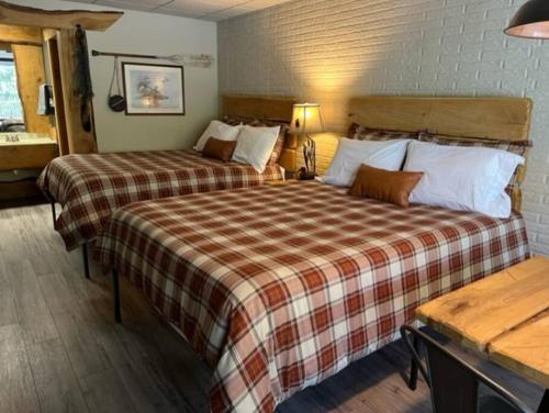 a hotel room with two beds and a sink at Stonegate Lodge 2 Queen Beds WIFI Roku TV Salt Water Pool Room #106 in Eureka Springs