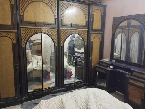 ein Schlafzimmer mit einem großen Holzschrank mit Glastüren in der Unterkunft حلوان in Aţ Ţarfāyah