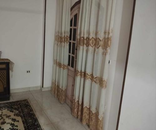 ein Zimmer mit einem Fenster mit Vorhängen darauf in der Unterkunft حلوان in Aţ Ţarfāyah