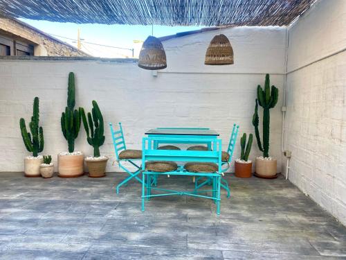 a blue table and chairs next to cactuses and plants at Casa en Palafrugell - Costa Brava in Palafrugell