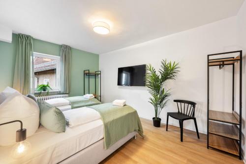 a bedroom with a bed and a tv on the wall at Sali Homes - Neuenstadt am Kocher in Neuenstadt am Kocher