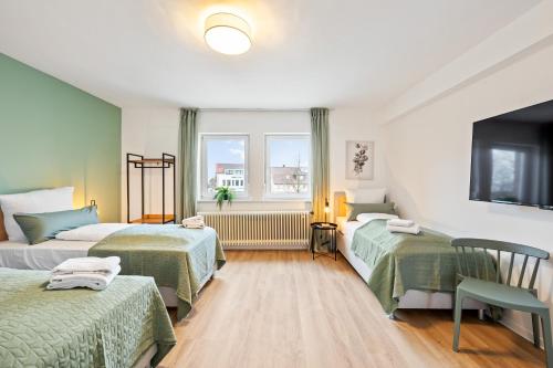 a hotel room with two beds and a tv at Sali Homes - Neuenstadt am Kocher in Neuenstadt am Kocher