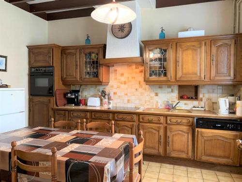 une cuisine avec des armoires en bois et une table à l'intérieur dans l'établissement Maison bretonne avec jardin, 2 chambres, centre de Perros-Guirec, proche plages et commerces - FR-1-368-385, à Perros-Guirec