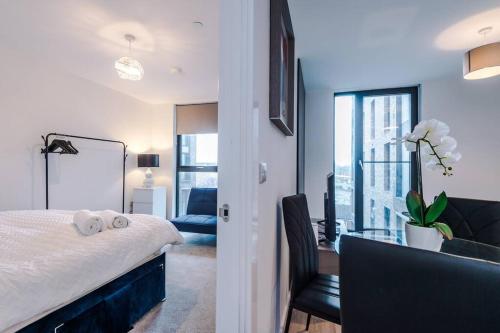 een slaapkamer met een bed en een bureau met een stoel bij Luxury King Size 1-Bed City Apartment - Free WI-FI in Preston