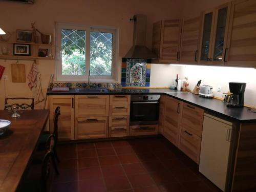 a kitchen with wooden cabinets and a stove top oven at Villa with a big garden in Athens