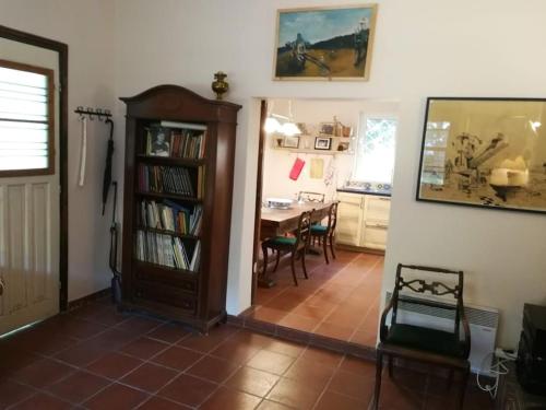 a living room with a book shelf and a table at Villa with a big garden in Athens