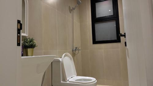 niewielka łazienka z toaletą i oknem w obiekcie شقة فاخرة بأسلوب فندقي و جلسة ريفية بدخول ذاتي w Rijadzie