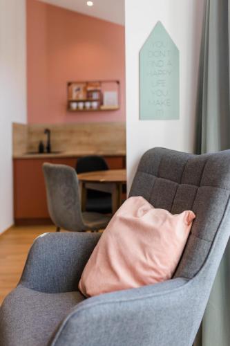 a gray couch with a pink pillow in a living room at Stadthotel Freilassing in Freilassing