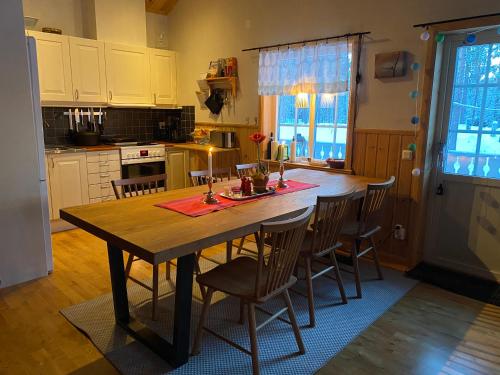 a kitchen with a wooden table and chairs at Fjällstuga i avskildhet in Idre