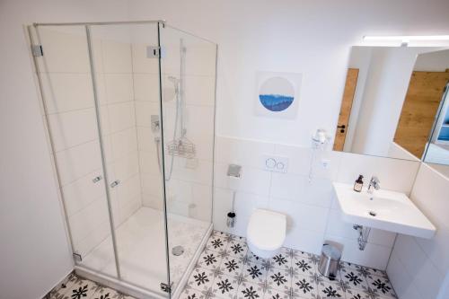 a bathroom with a shower and a toilet and a sink at Stadthotel Freilassing in Freilassing