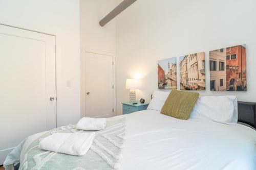 - une chambre avec un lit blanc orné d'une peinture murale dans l'établissement McCormick Place 3BR-2BA with Optional Parking - sleeps 8, à Chicago