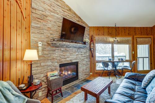 a living room with a fireplace and a blue couch at Pool and River Access Mt Bachelor Condo with Patio! in Bend