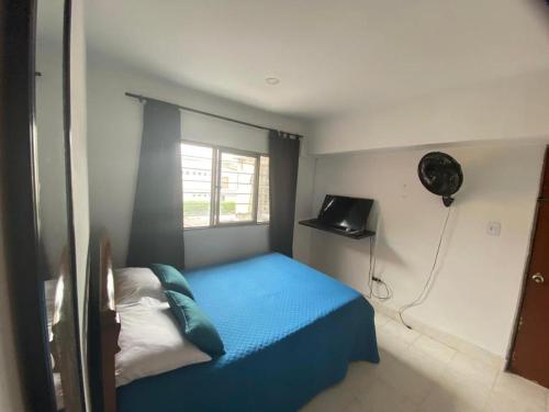 Schlafzimmer mit einem blauen Bett und einem Ventilator in der Unterkunft Cali Bella Alamos in Cali