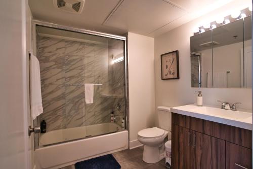 uma casa de banho com um chuveiro, um WC e um lavatório. em McCormick Place 2b-2b family unit with optional parking sleeps up to 6 em Chicago