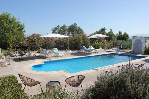 uma piscina com cadeiras, mesas e guarda-sóis em Casa De La Familia - Casa Rural em Baza