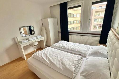 Habitación blanca con cama y espejo en Apartment 14 im Herzen von Linz en Linz