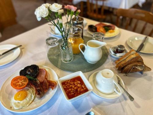 a table with plates of breakfast food on it at Church Farm Guest House in Horsford