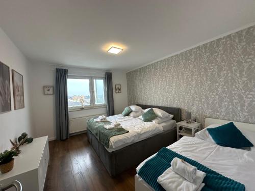 ein Hotelzimmer mit 2 Betten und einem Fenster in der Unterkunft SUITE4ME - Moderne Ferienwohnung I Küche I Balkon I Mainz-Kostheim in Wiesbaden