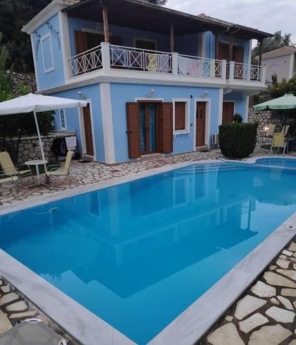 a villa with a swimming pool in front of a house at AGIOS NIKITAS DOLPHINS in Agios Nikitas