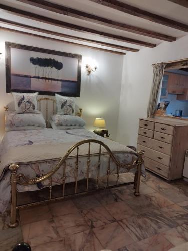 a bedroom with a large bed and a dresser at Stargazer Studio in Saint-Chamassy