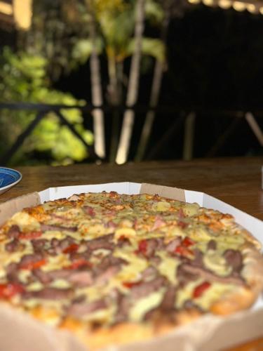 a pizza sitting in a box on a table at Mirante do Lago in Capitólio