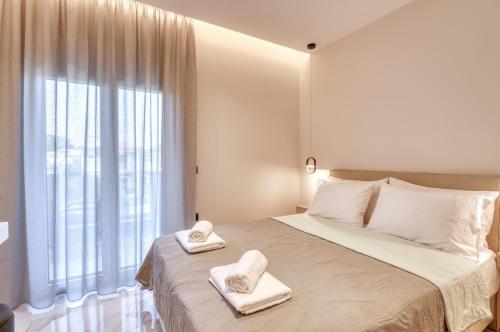 una camera da letto con un letto grande con asciugamani sopra di Anesis Deluxe Apartment 1 a Gaïtánion