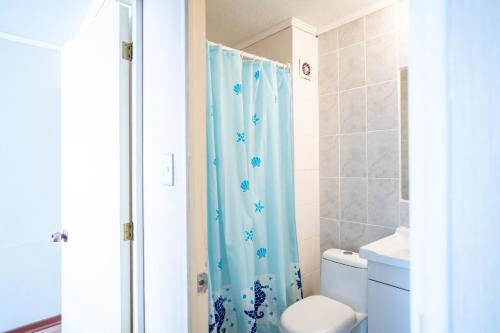 a bathroom with a blue shower curtain and a toilet at Disfruta de un tranquilo departamento en el centro a pasos del Hipodromo in Santiago