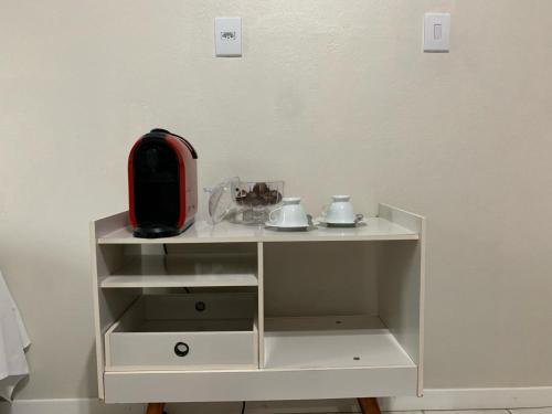 Biała szafka z czerwonym urządzeniem. w obiekcie Quarto Aconchego w mieście Pomerode